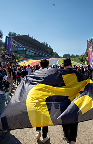 Fans with Global-Tickets flag walking toward motorsport track